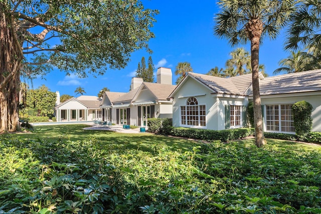 view of front of home with a patio and a front yard