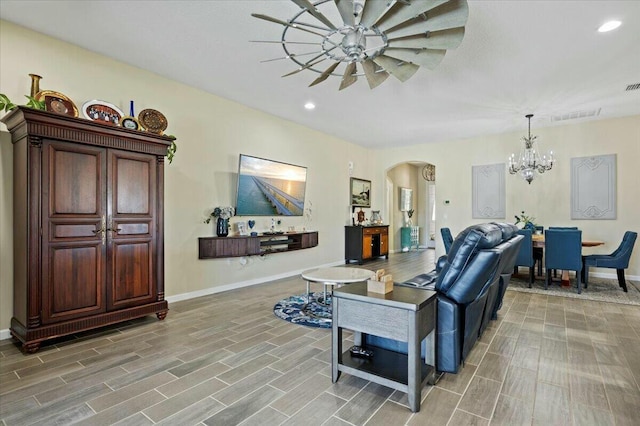 living room with ceiling fan with notable chandelier