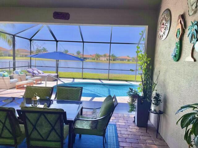 view of swimming pool with an outdoor hangout area, a lanai, a patio area, and a water view