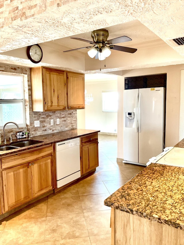 kitchen with white appliances, ceiling fan, a tray ceiling, a sink, and backsplash