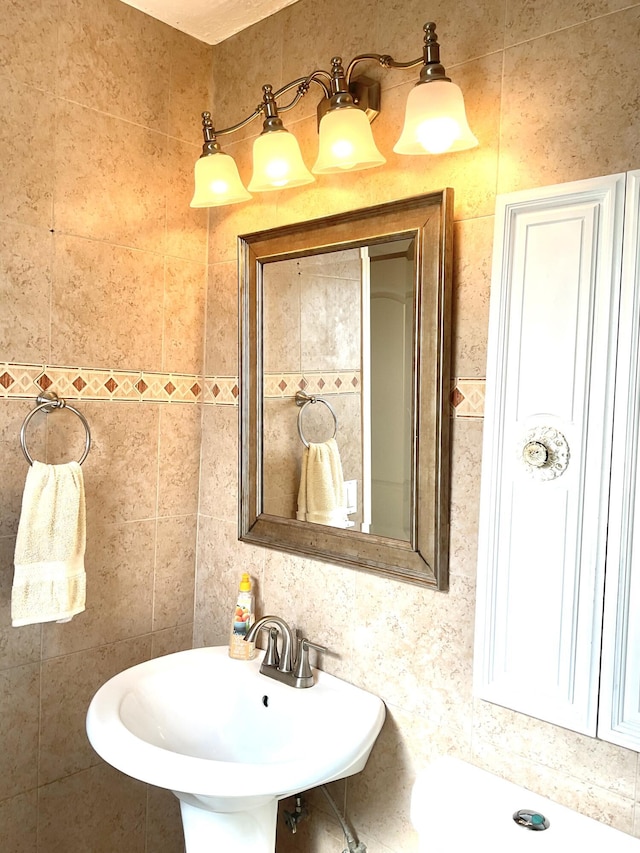 bathroom with a sink and tile walls