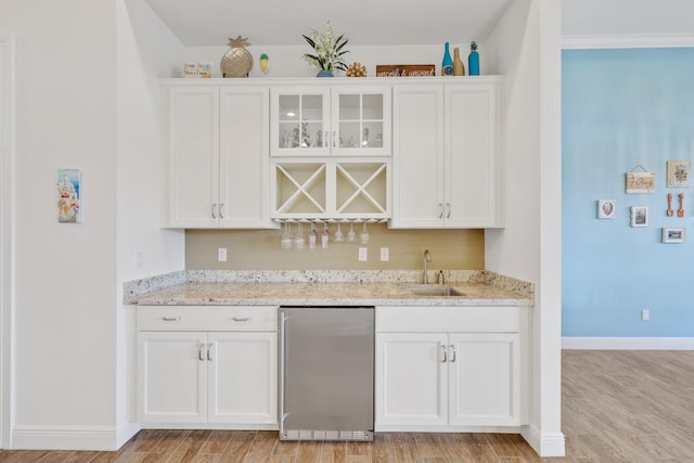 bar with white cabinetry and stainless steel fridge