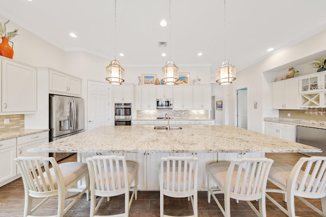 kitchen with white cabinetry, stainless steel appliances, a large island, and sink