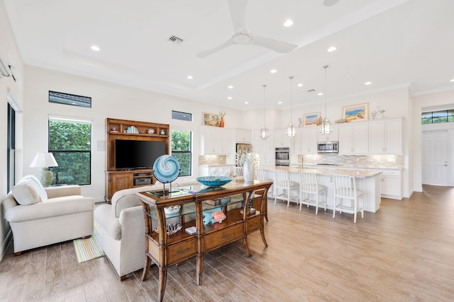 living room with ceiling fan, a healthy amount of sunlight, and light hardwood / wood-style floors