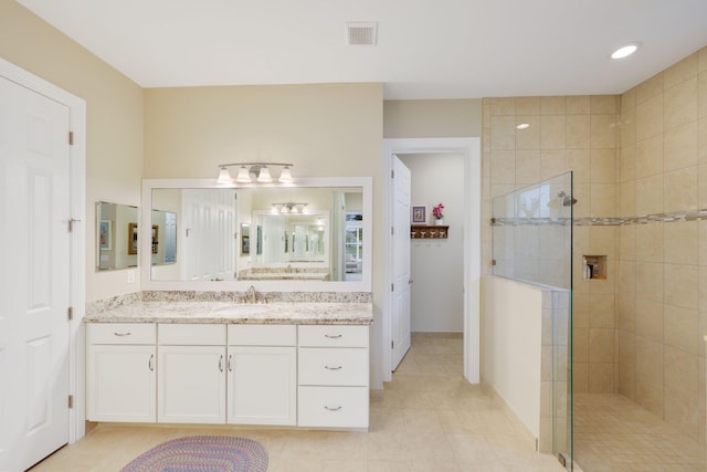 bathroom featuring vanity and tiled shower