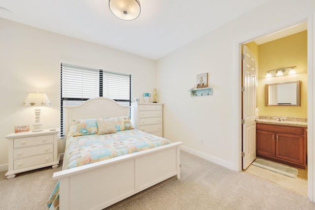 bedroom with lofted ceiling, connected bathroom, light colored carpet, and sink