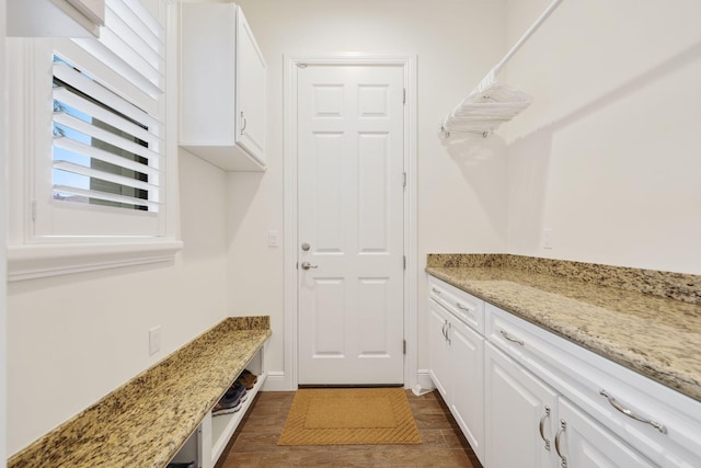 interior space featuring light stone counters and white cabinets