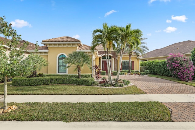 mediterranean / spanish home with a front lawn