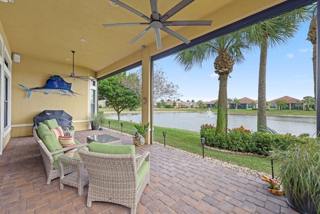 view of patio / terrace with area for grilling, ceiling fan, and a water view