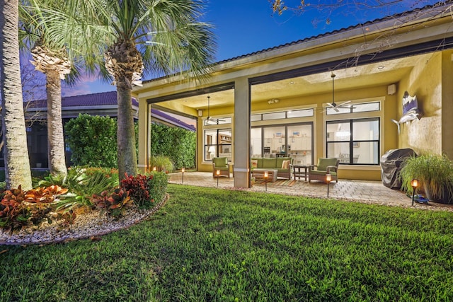 exterior space with a patio, outdoor lounge area, ceiling fan, and a lawn