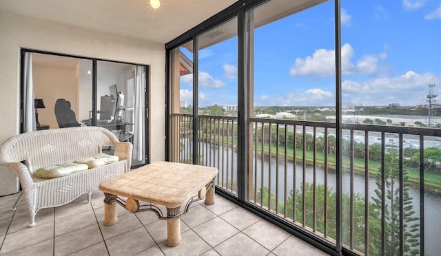 sunroom featuring a water view