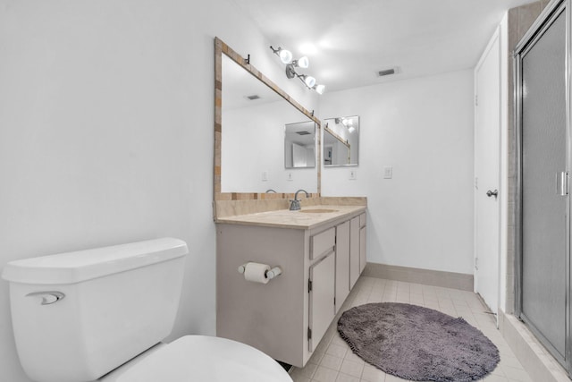 bathroom with toilet, vanity, tile patterned flooring, and a shower with shower door