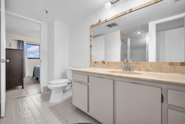 bathroom with toilet, a shower with door, vanity, and tile patterned flooring