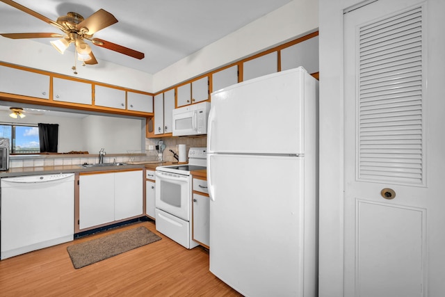 kitchen featuring decorative backsplash, white appliances, light wood-type flooring, white cabinets, and sink