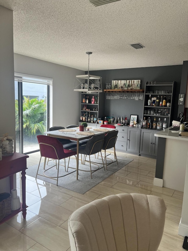 dining room with a textured ceiling and bar