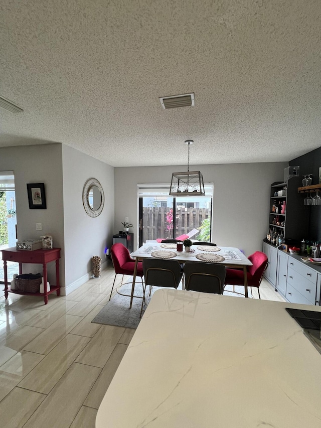 dining space with a textured ceiling and a healthy amount of sunlight