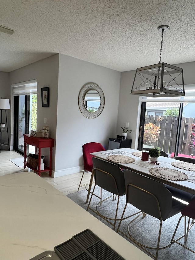 dining space featuring a textured ceiling and an inviting chandelier