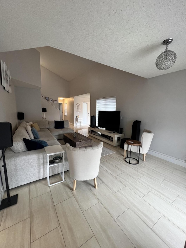 living room featuring a textured ceiling and lofted ceiling