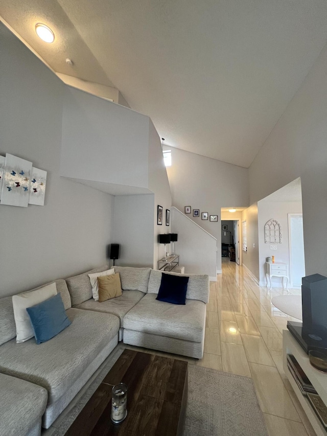 living room featuring high vaulted ceiling and light tile patterned floors