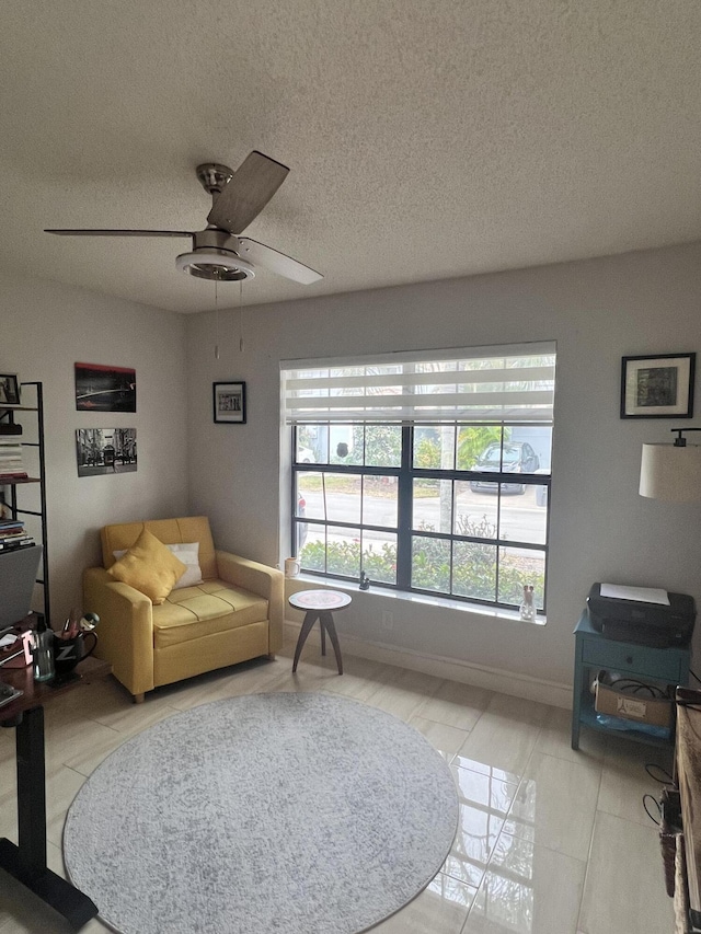 tiled living room with ceiling fan and a textured ceiling