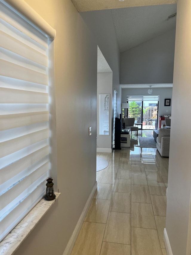 hallway with light tile patterned floors and a textured ceiling