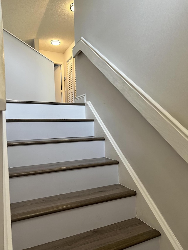 stairs with a textured ceiling