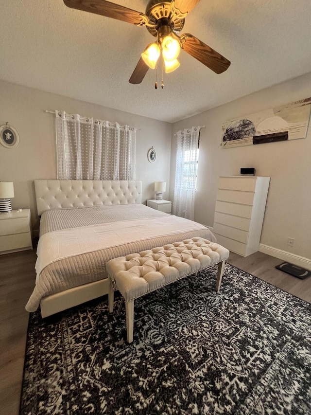 bedroom with ceiling fan, a textured ceiling, and hardwood / wood-style flooring