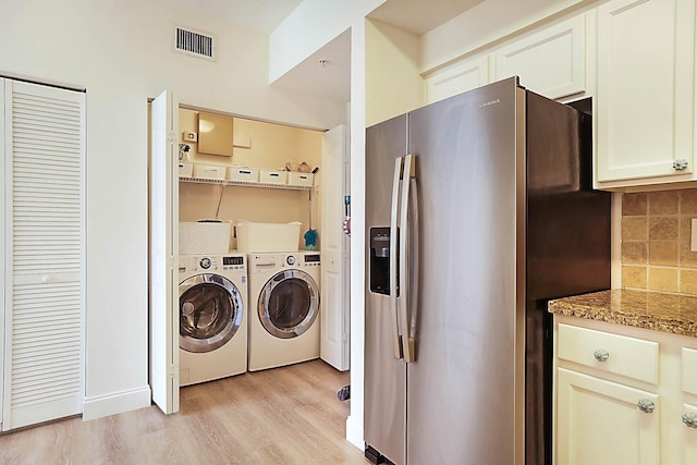 washroom with light wood-type flooring and independent washer and dryer