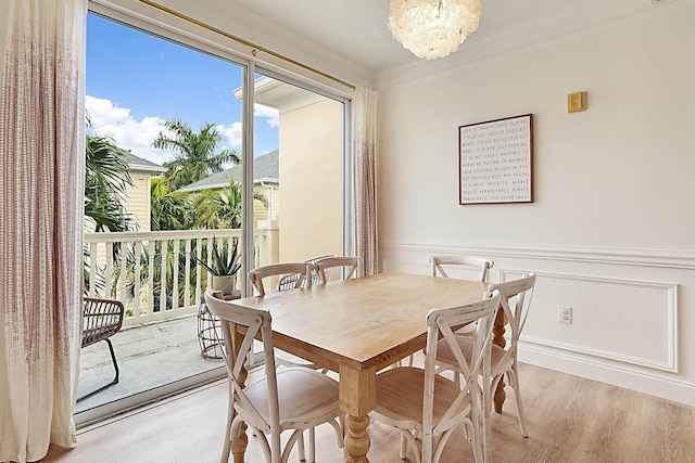 dining room with an inviting chandelier, ornamental molding, and light hardwood / wood-style floors