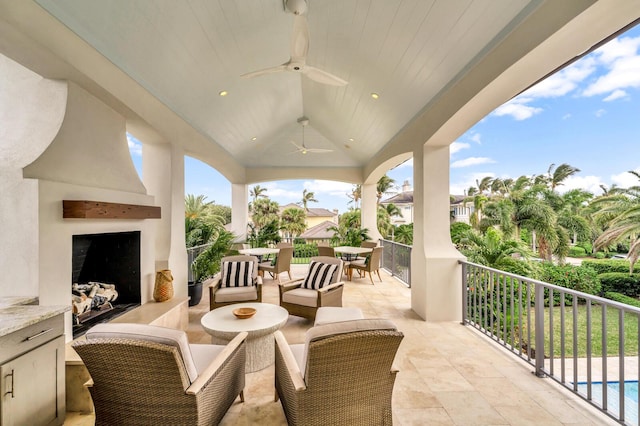 view of patio with ceiling fan and an outdoor living space with a fireplace