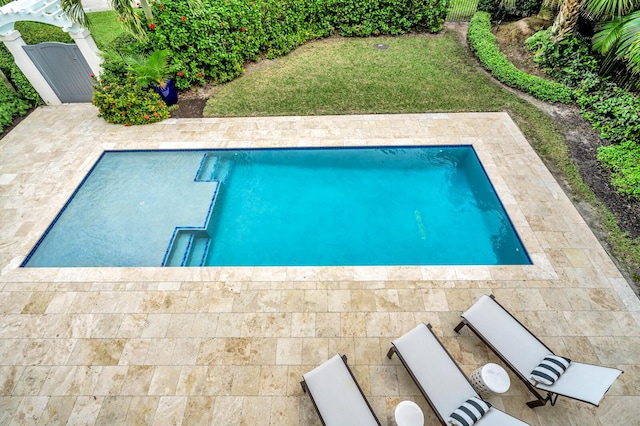 view of swimming pool featuring a yard