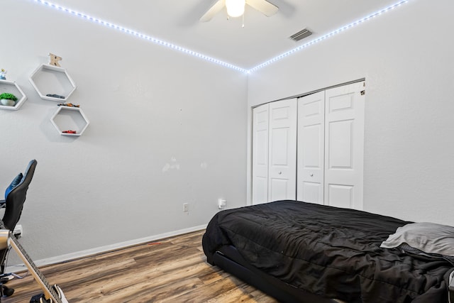 bedroom with hardwood / wood-style flooring, ceiling fan, and a closet