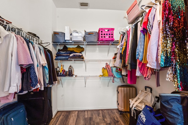 walk in closet with dark hardwood / wood-style floors