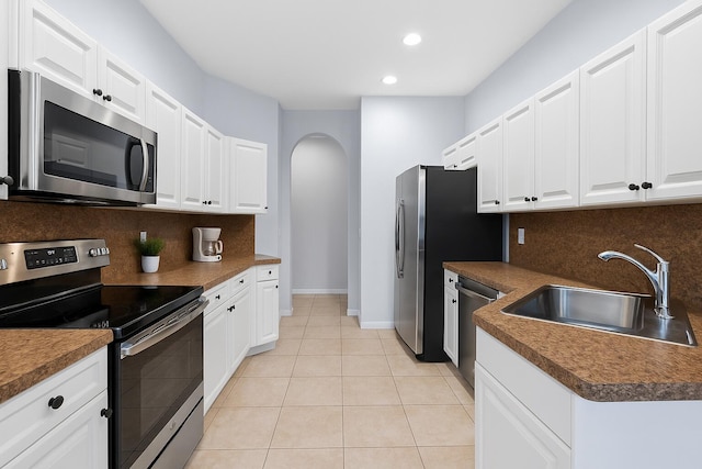 5138 White Oleander, West Palm Beach, FL 33415 - kitchen featuring appliances with stainless steel finishes, a sink, arched walkways, tasteful backsplash, and recessed lighting