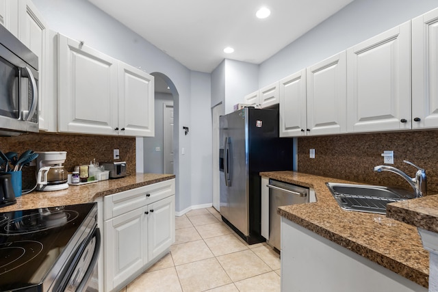 5138 White Oleander, West Palm Beach, FL 33415 - kitchen featuring stainless steel appliances, a sink, light tile patterned floors, arched walkways, and tasteful backsplash