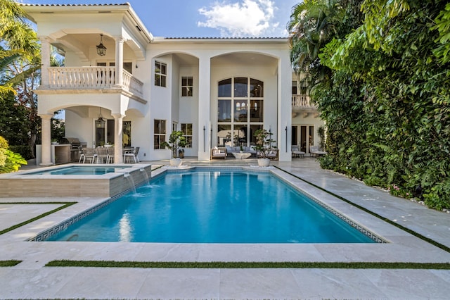 view of pool featuring pool water feature, a patio area, and an in ground hot tub