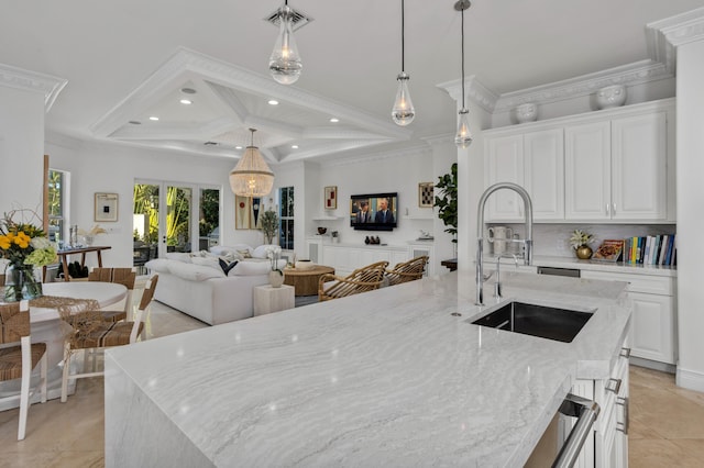 kitchen featuring sink, white cabinetry, coffered ceiling, beamed ceiling, and a large island with sink