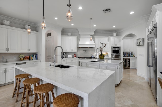 kitchen with pendant lighting, sink, backsplash, custom exhaust hood, and a spacious island