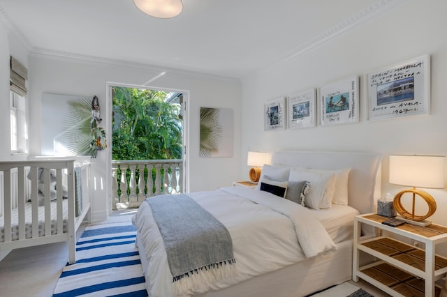 carpeted bedroom featuring crown molding and access to exterior