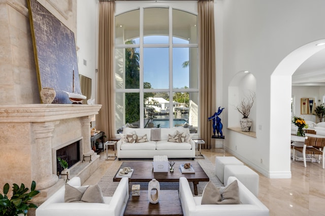 living room with a fireplace and a high ceiling