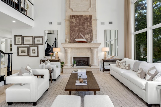 living room with a towering ceiling and a fireplace