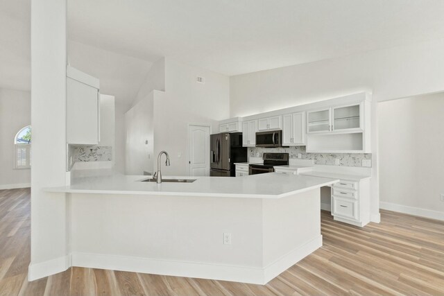 kitchen featuring ceiling fan, vaulted ceiling, decorative backsplash, sink, and appliances with stainless steel finishes