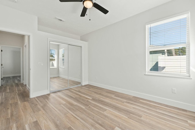 unfurnished bedroom with ceiling fan, light hardwood / wood-style floors, and a closet