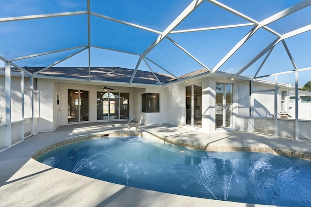 view of swimming pool with glass enclosure, a patio area, and ceiling fan