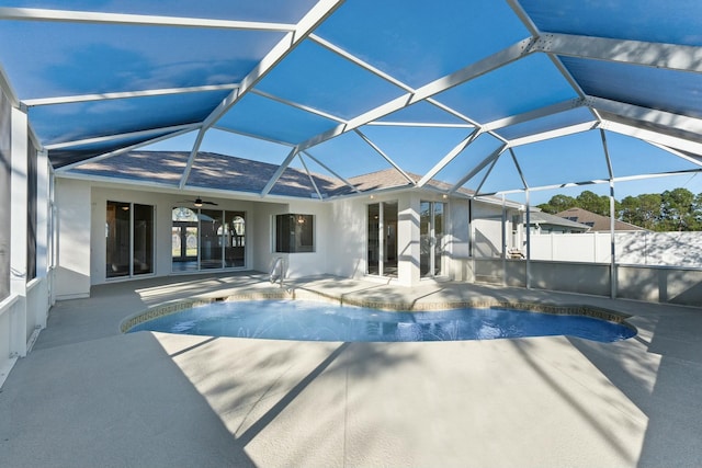 view of swimming pool featuring ceiling fan, a lanai, and a patio