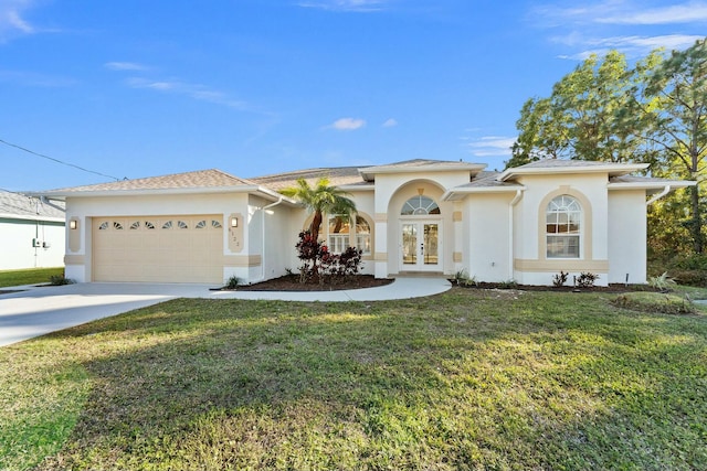 view of front facade with a front yard, a garage, and french doors