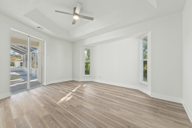 unfurnished room with ceiling fan, plenty of natural light, and a raised ceiling