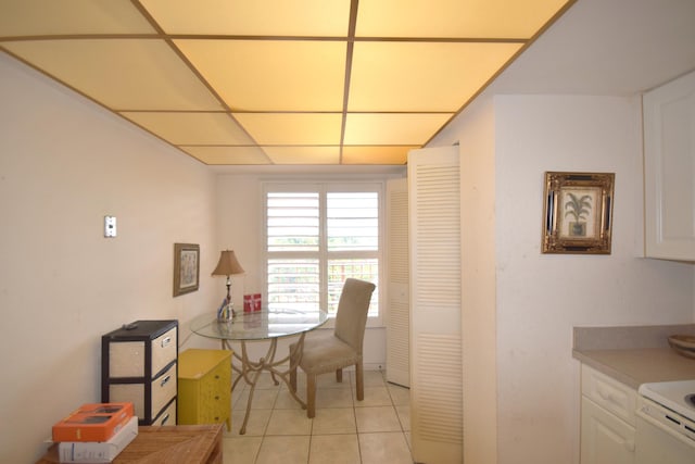 dining space featuring a paneled ceiling and light tile patterned floors