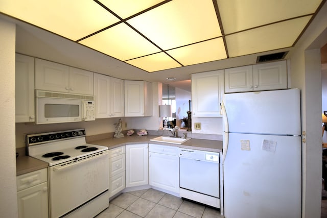 kitchen with sink, white appliances, white cabinets, and light tile patterned floors