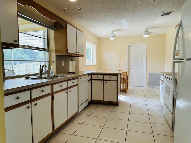 kitchen featuring ceiling fan, kitchen peninsula, sink, white appliances, and white cabinetry